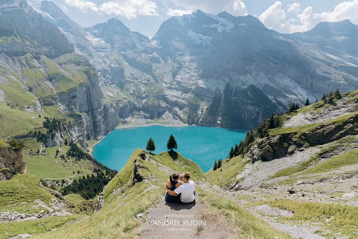 Holden and Misha sitting at the famous cliff edge viewpoint above Lake Oeschinensee