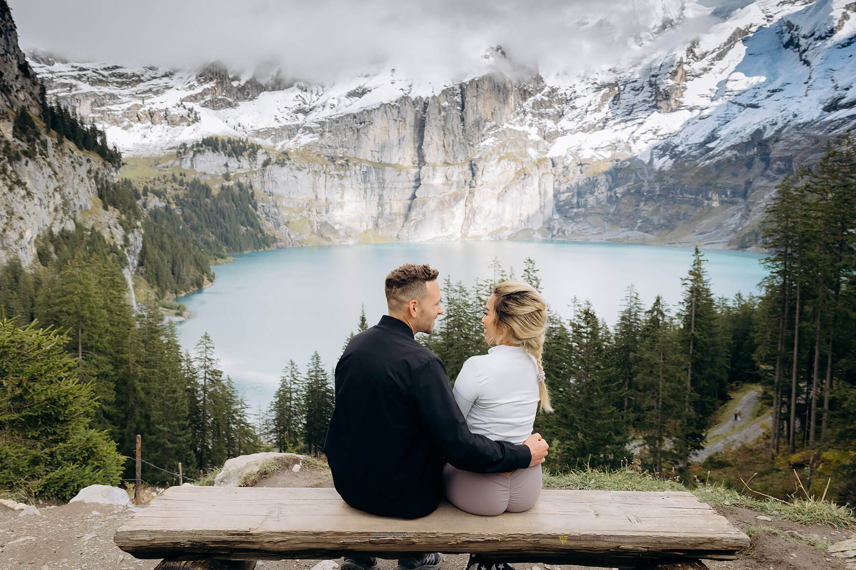 Romantic marriage proposal at Oeschinensee surrounded by turquoise water and alpine peaks.