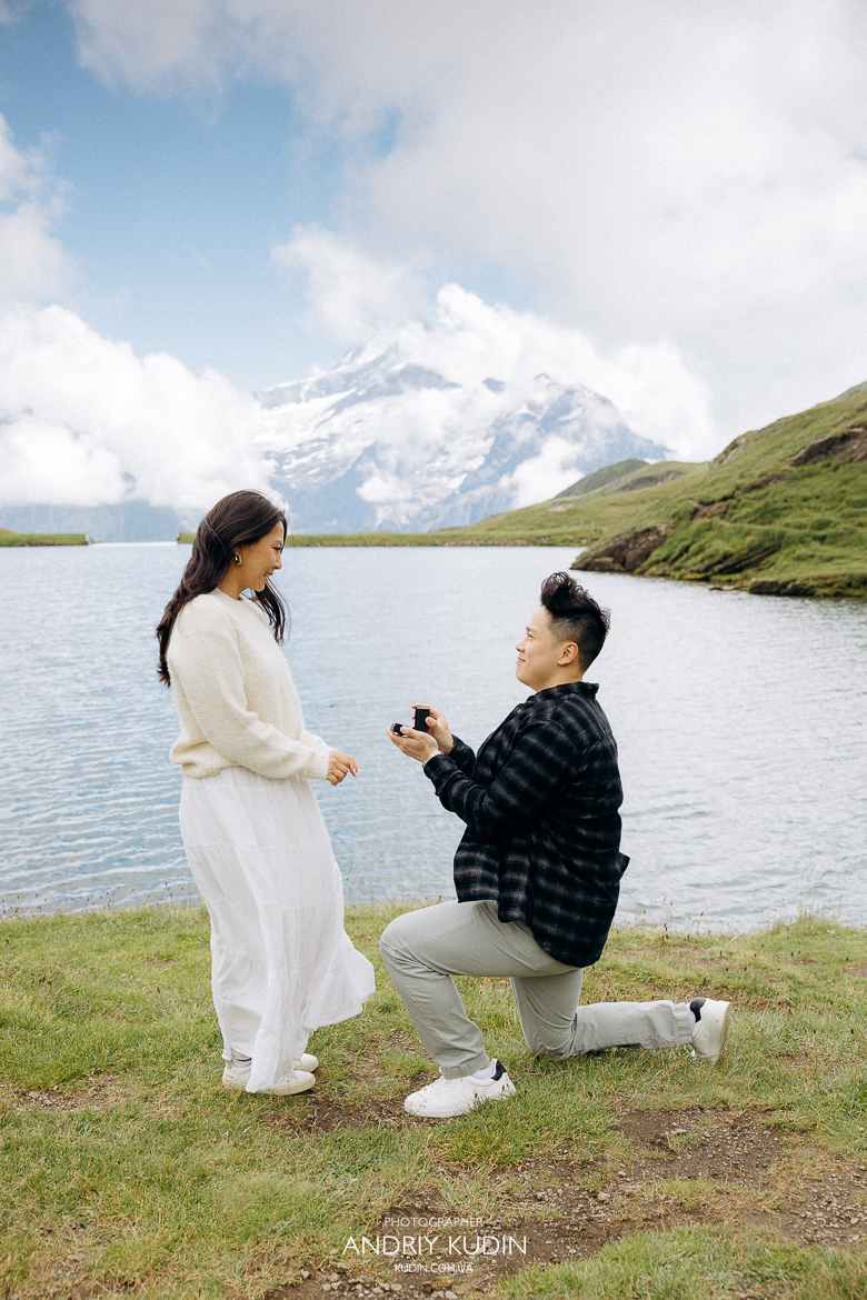 Man kneeling during proposal by Bachalpsee Lake, Grindelwald