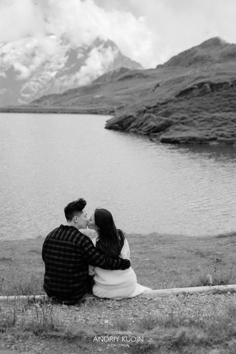 Couple celebrating engagement by Bachalpsee Lake with Alps panorama