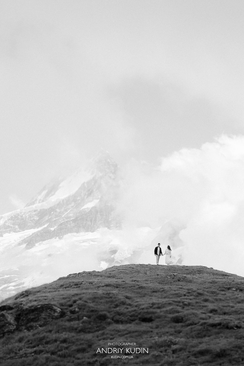 Couple celebrating engagement by Bachalpsee Lake with Alps panorama
