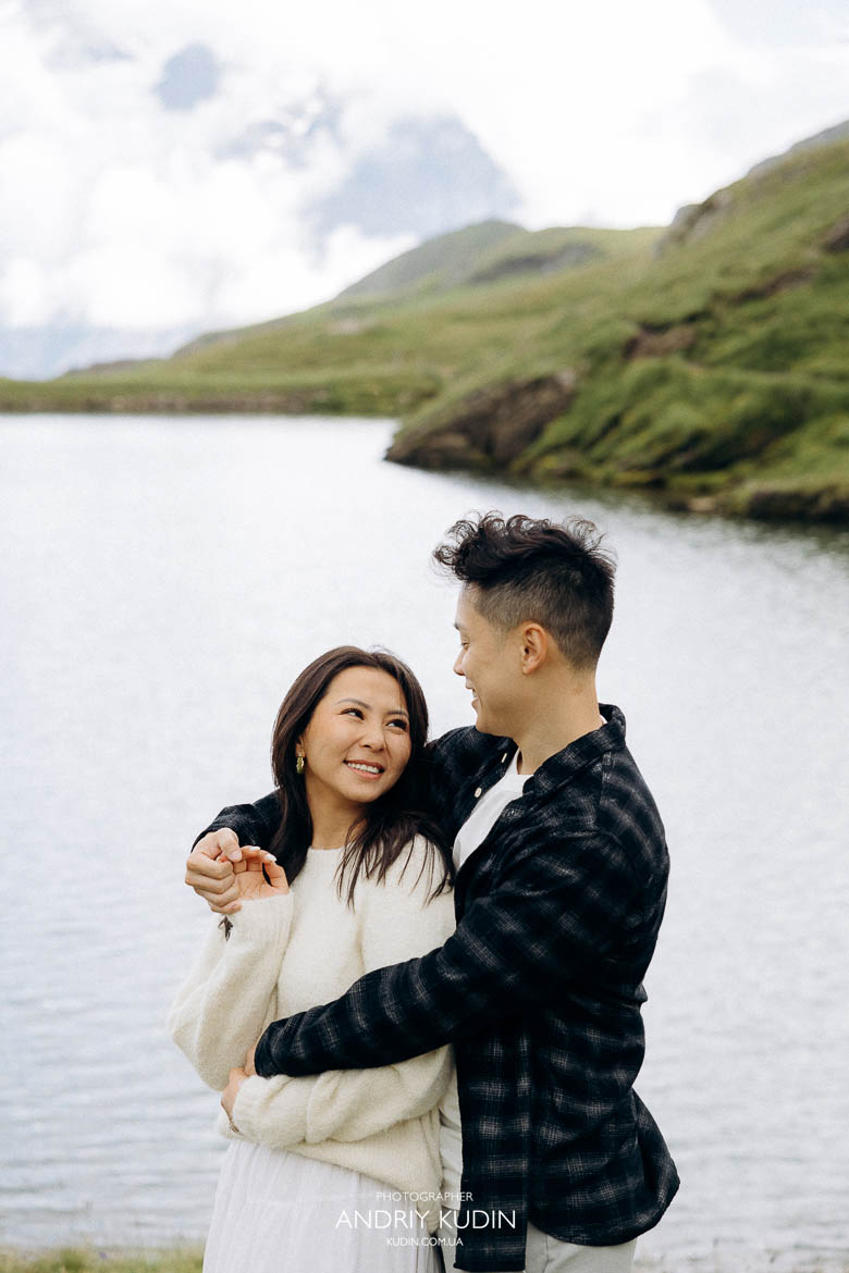 Romantic proposal scene at Grindelwald First with lake reflections