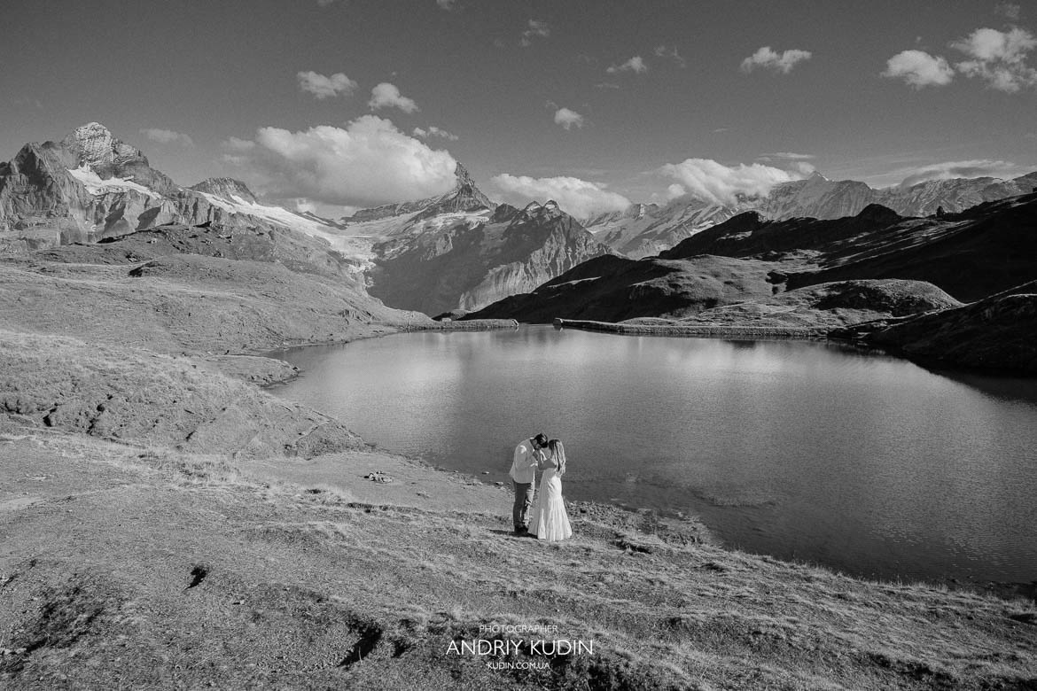 Couple holding hands in Lauterbrunnen Valley with Staubbach Falls behind them.