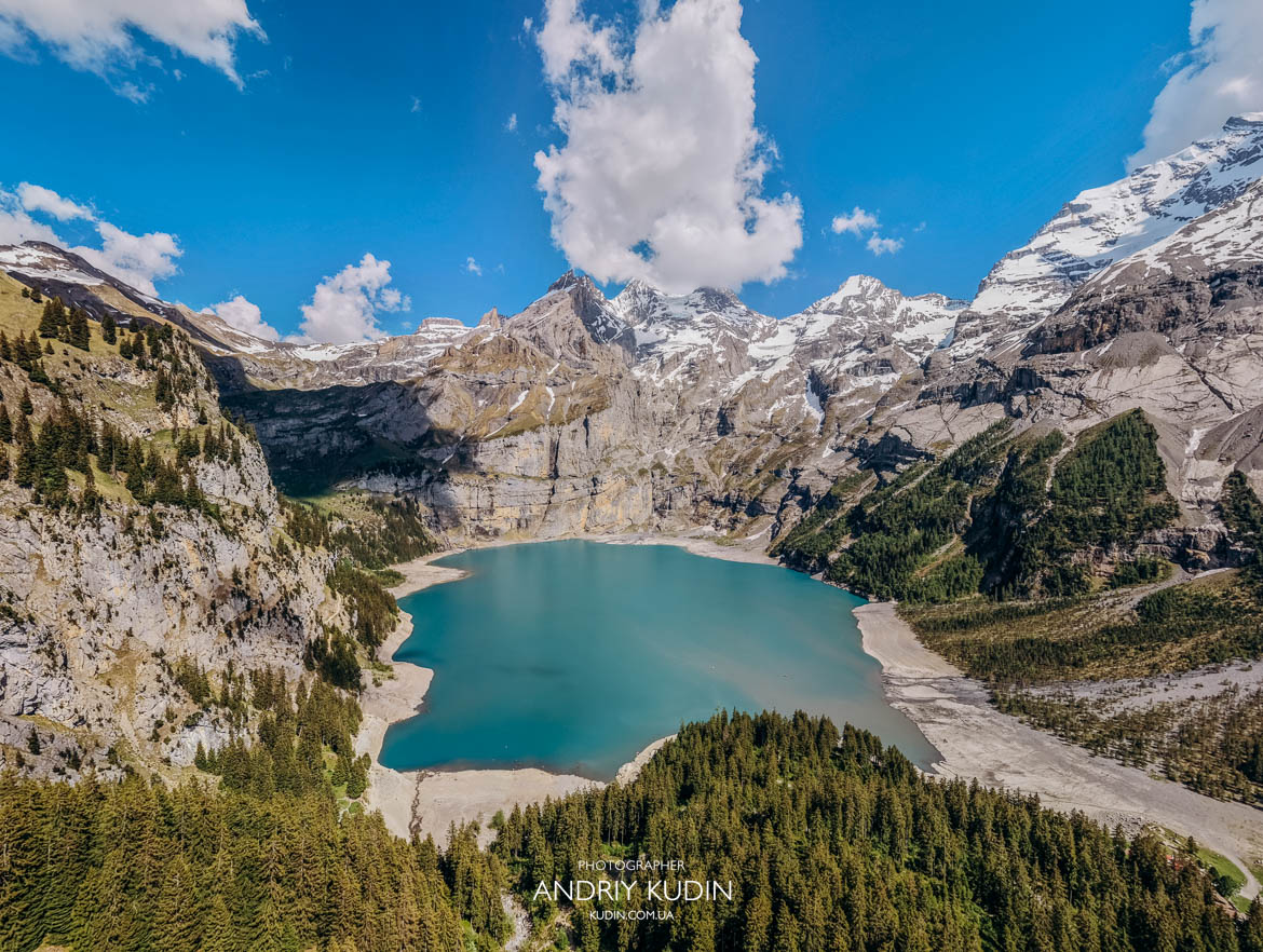Panoramic turquoise water of Lake Oeschinensee framed by Swiss Alps mountains captured by Switzerland proposal photographer Panoramic turquoise water of Lake Oeschinensee framed by Swiss Alps mountains captured by Switzerland proposal photographer