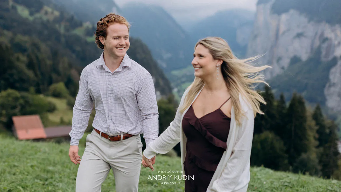 Smiling bride-to-be holding hands with partner showing engagement ring in Lauterbrunnen. Photo by switzerland proposal photographer.