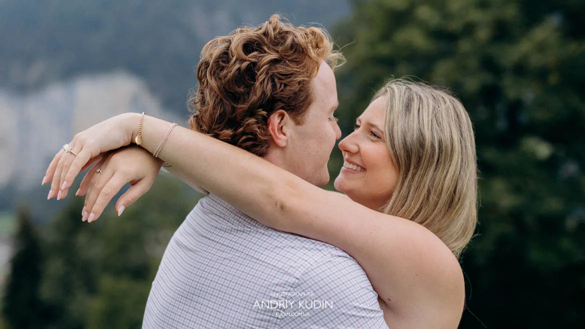 engagement ring on woman's hand embracing partner after surprise proposal in Lauterbrunnen