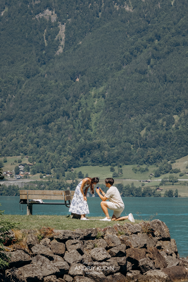 Couple proposing on Iseltwald wooden pier with Lake Brienz view. Marriage proposal photoshoot in Iseltwald, Switzerland.