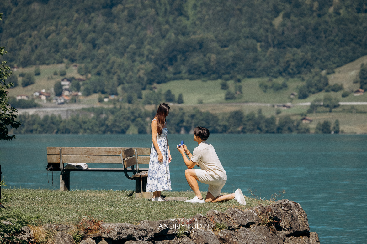 Couple proposing on Iseltwald wooden pier with Lake Brienz view. Marriage proposal photoshoot in Iseltwald, Switzerland.