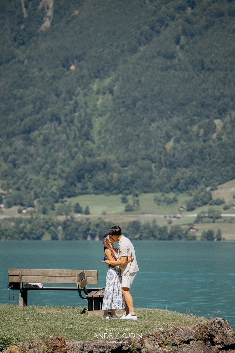 Couple proposing on Iseltwald wooden pier with Lake Brienz view. Marriage proposal photoshoot in Iseltwald, Switzerland.