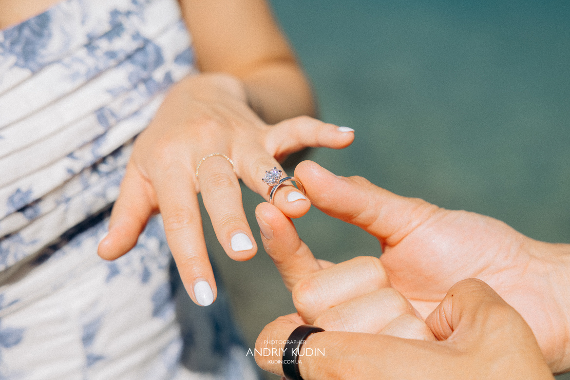 Couple proposing on Iseltwald wooden pier with Lake Brienz view. Marriage proposal photoshoot in Iseltwald, Switzerland.