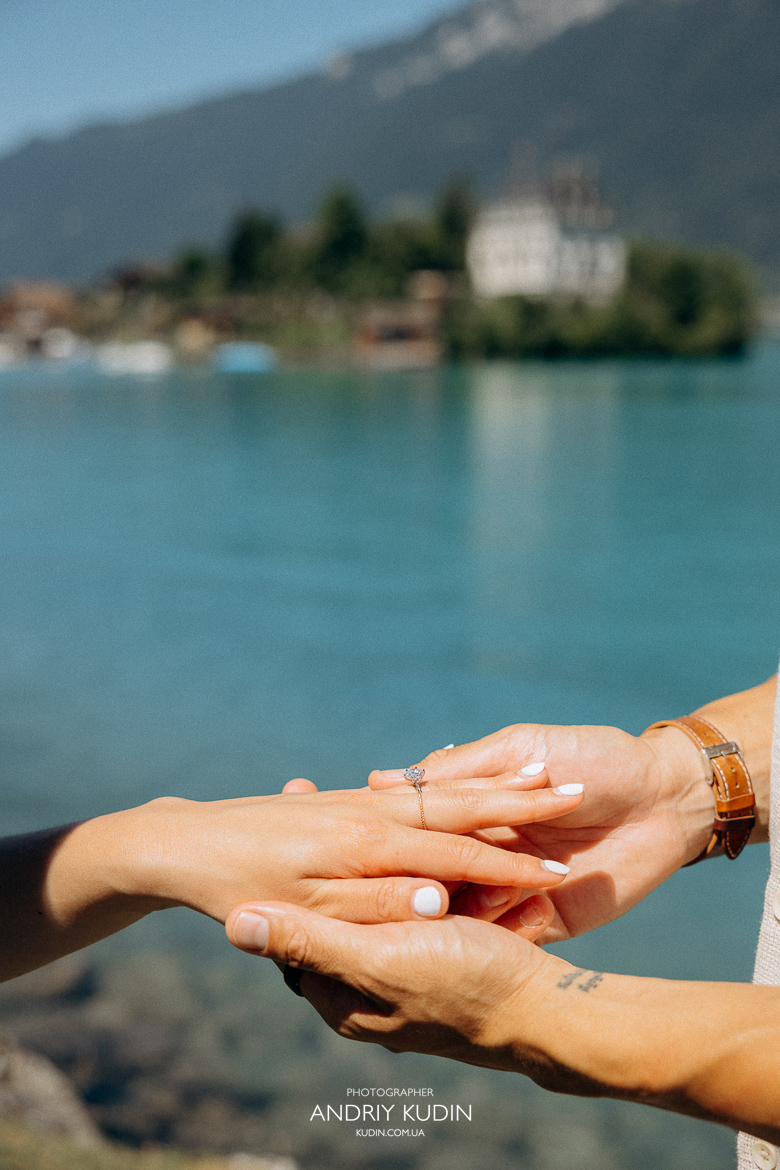 Couple proposing on Iseltwald wooden pier with Lake Brienz view. Marriage proposal photoshoot in Iseltwald, Switzerland.