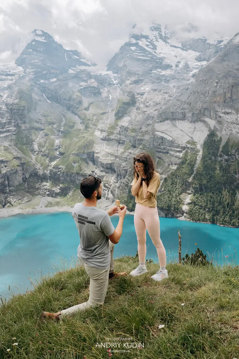 Couple proposing on Oeschinensee panorama trail with turquoise lake