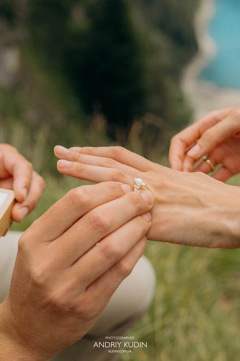 Marriage proposal photography showing a ring being placed on a finger at Lake Oeschinen in Switzerland. Marriage proposal photography showing a ring being placed on a finger at Lake Oeschinen in Switzerland.