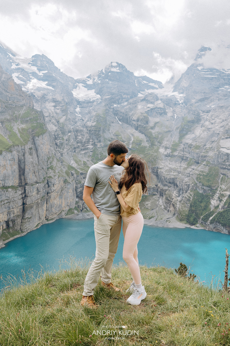 Couple-kissing-on-Oeschinensee-hike-with-Bernese-Alps-background