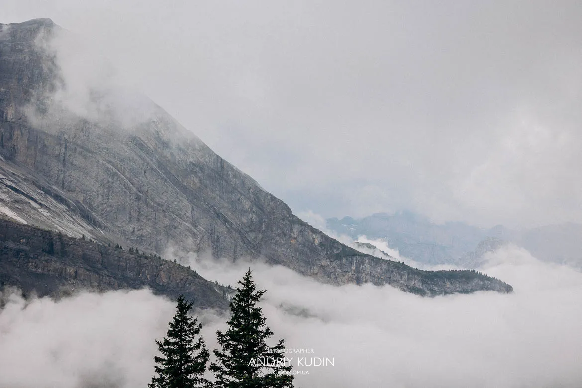Misty alpine mountains above Lake Oeschinen with evergreen trees rising through fog, photographed for Lake Oeschinen proposal sessions in Switzerland. Misty alpine mountains above Lake Oeschinen with evergreen trees rising through fog, photographed for Lake Oeschinen proposal sessions in Switzerland.