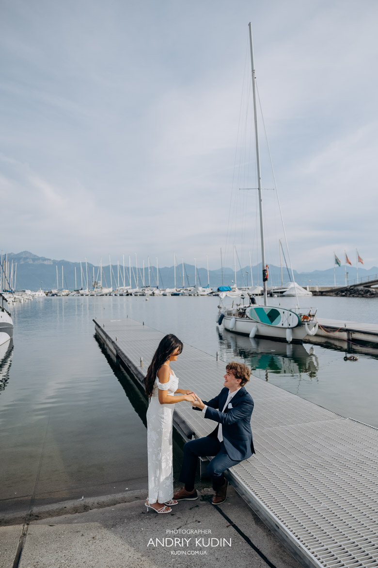 Lausanne wedding photographer captures couple kissing by Lake Geneva at sunset with Alps in background.