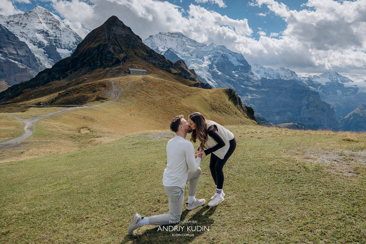 Romantic engagement kiss in Swiss mountains