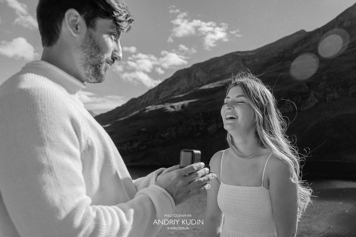 Couple smiling after engagement in snowy Swiss Alps.