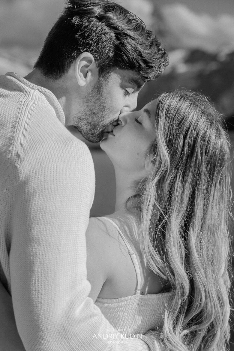Couple kissing after proposal by Lake Brienz turquoise water.