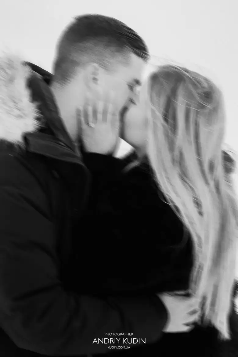 Ecstatic Mackenzie shows off her engagement ring while hugging Nelson on the terrace at Grindelwald First, overlooking the valley and snow-covered peaks.