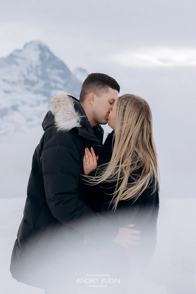 Couple engaged on Grindelwald First surrounded by snow and clouds