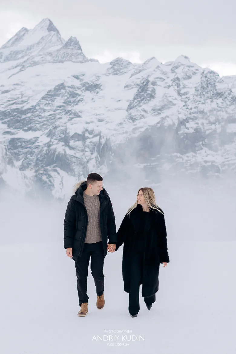 Couple engaged on Grindelwald First surrounded by snow and clouds