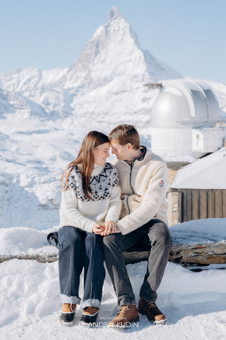 Happy couple celebrating engagement at Gornergrat observation deck.