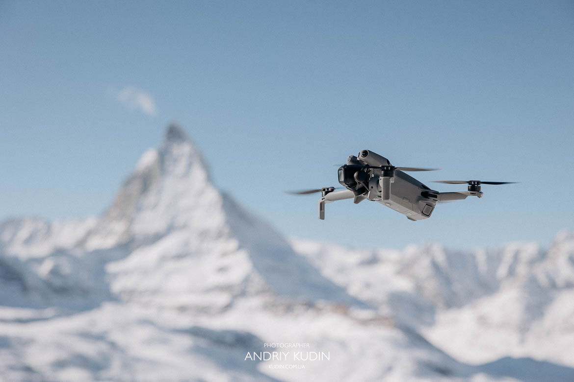 Cinematic drone shot of the red Gornergrat Bahn train winding through the Swiss Alps.