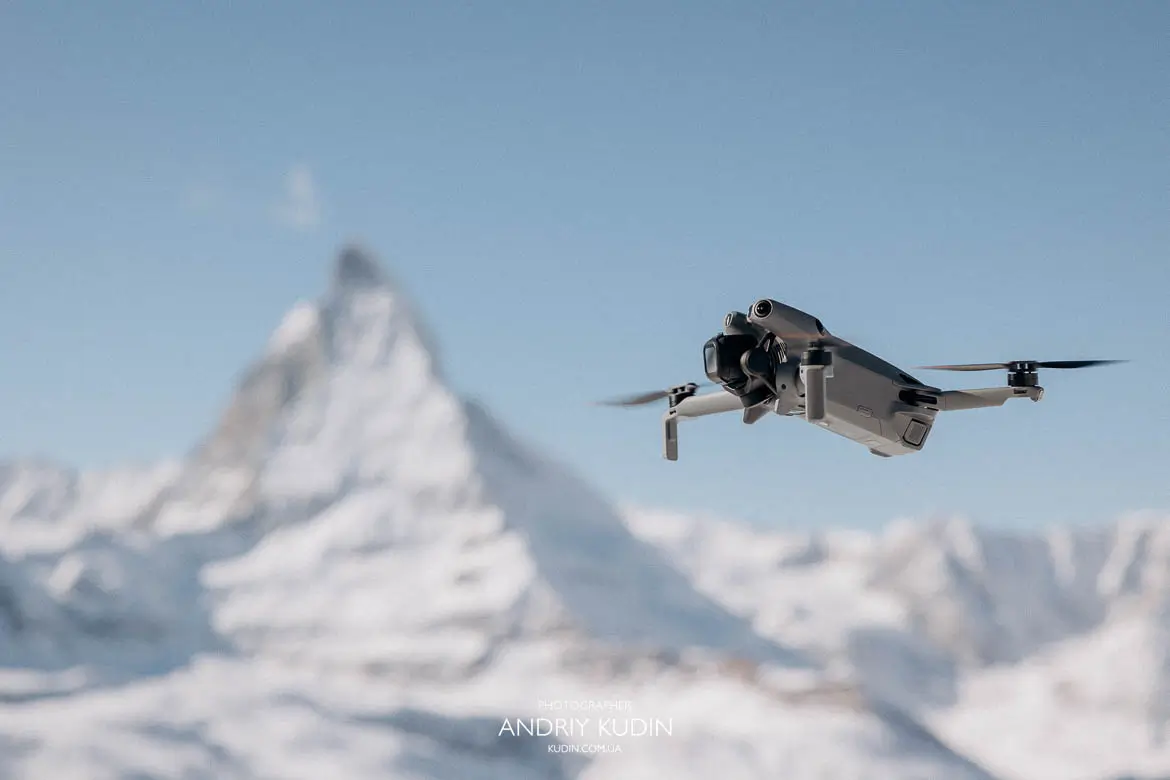 Cinematic drone shot of the red Gornergrat Bahn train winding through the Swiss Alps.