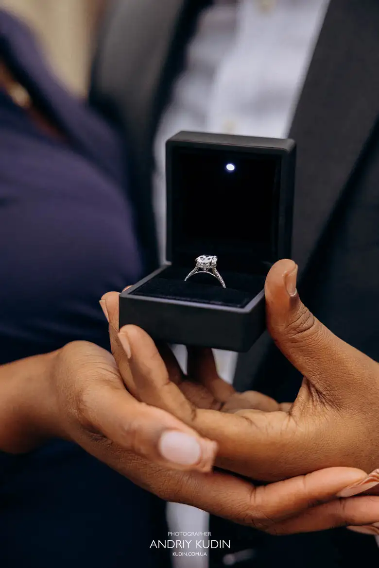 Romantic proposal in Zurich with engagement ring box and emotional connection visible between the couple