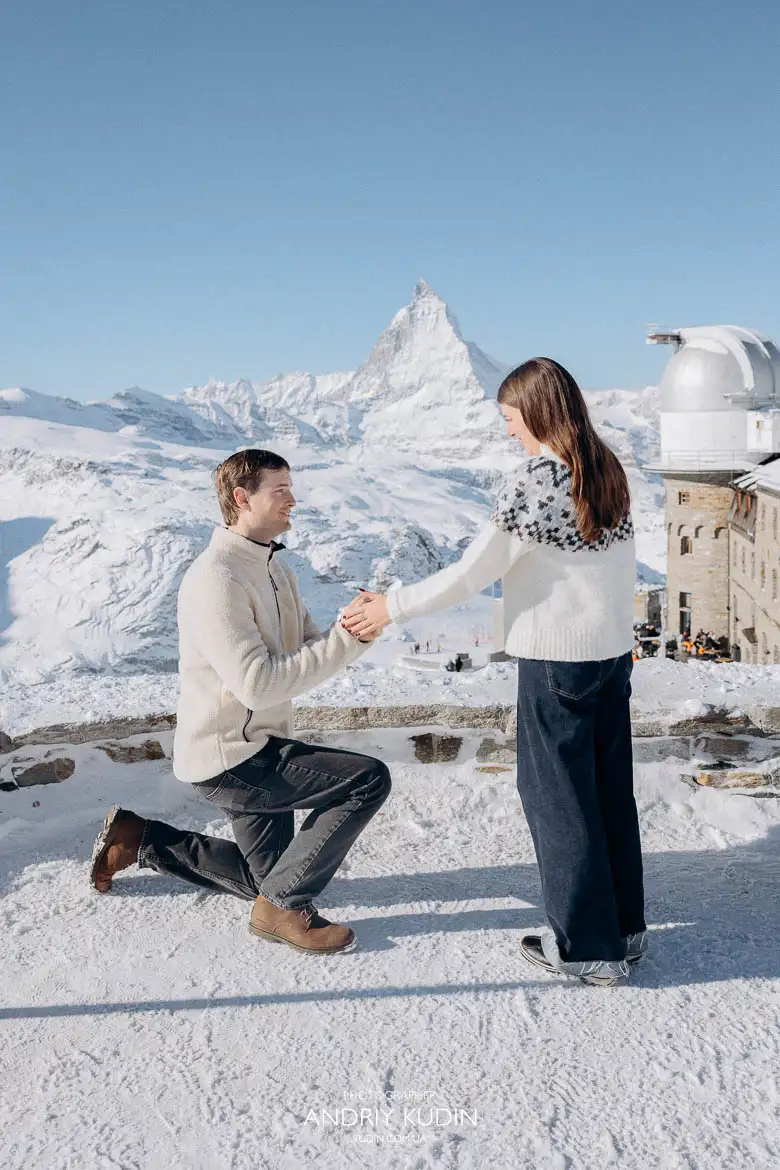 man-proposing-on-knee-snowy-mountain-matterhorn-view