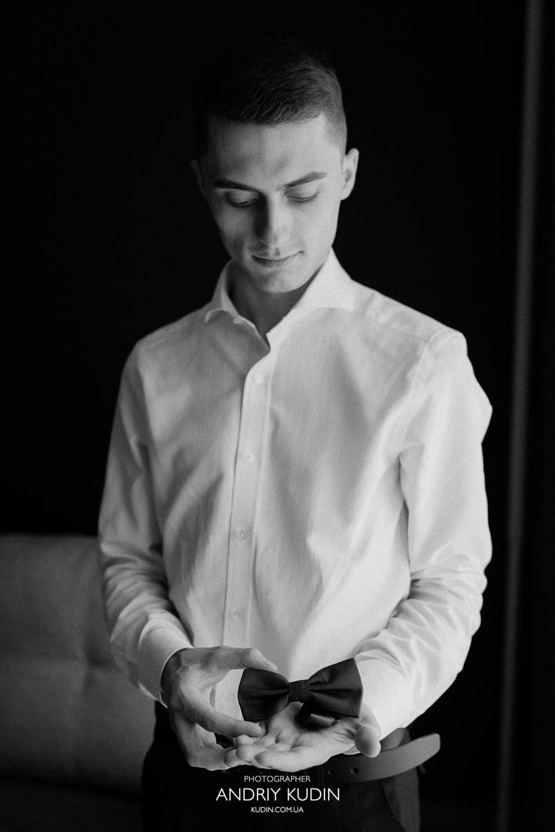 Bräutigam mit Freunden beim Getting Ready Bräutigam richtet seine Krawatte