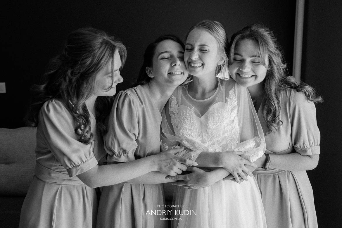 Braut lacht mit ihren Freundinnen Emotionale Umarmung der Braut mit Brautjungfern