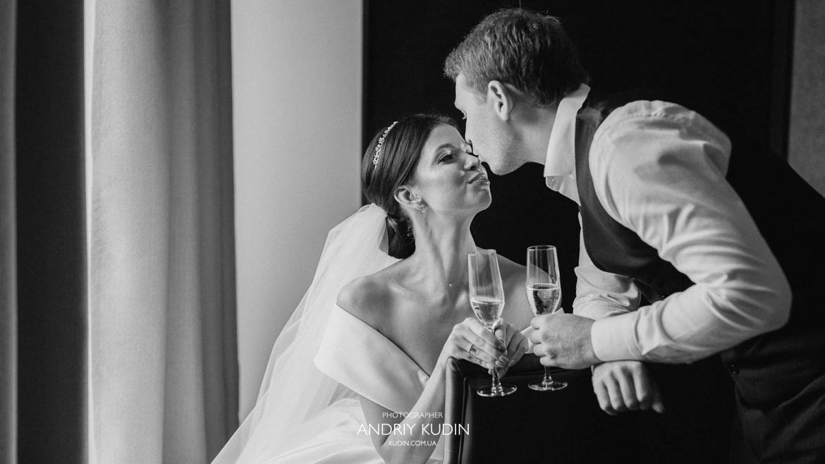 Braut und Bräutigam stoßen mit Champagnergläsern an und schauen sich verliebt im Hotel in Zürich an