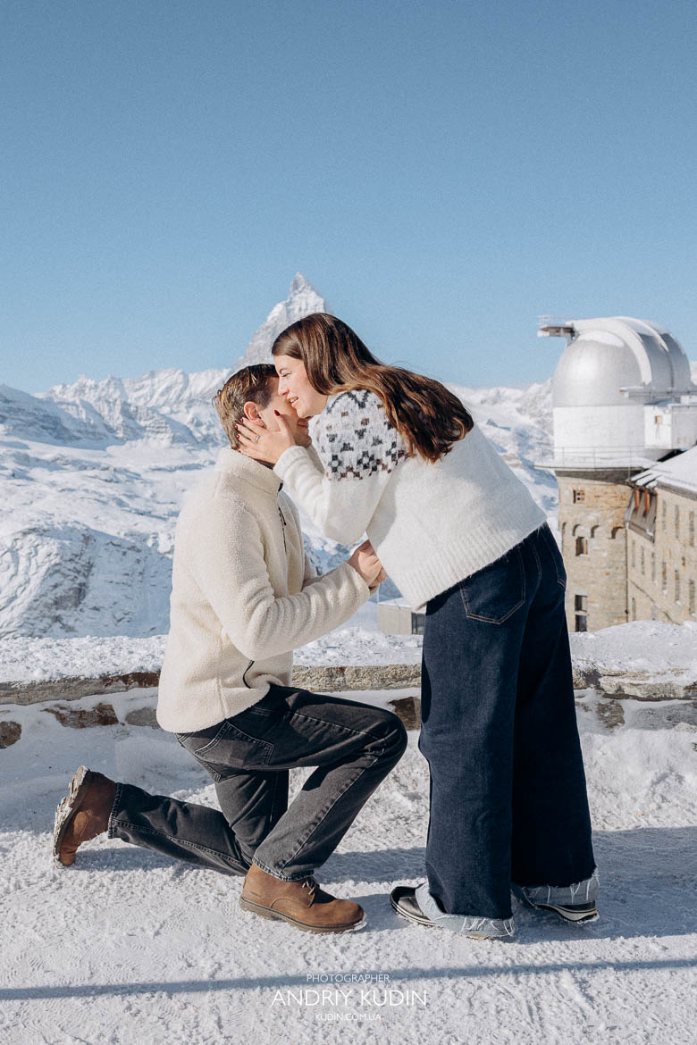Man kneeling for a swiss alps proposal in the snow near Zermatt.