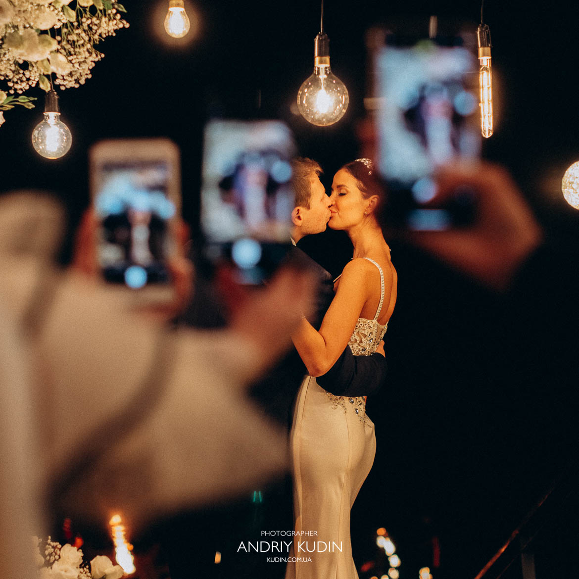 Braut und Bräutigam küssen sich nach dem Anschneiden der Hochzeitstorte