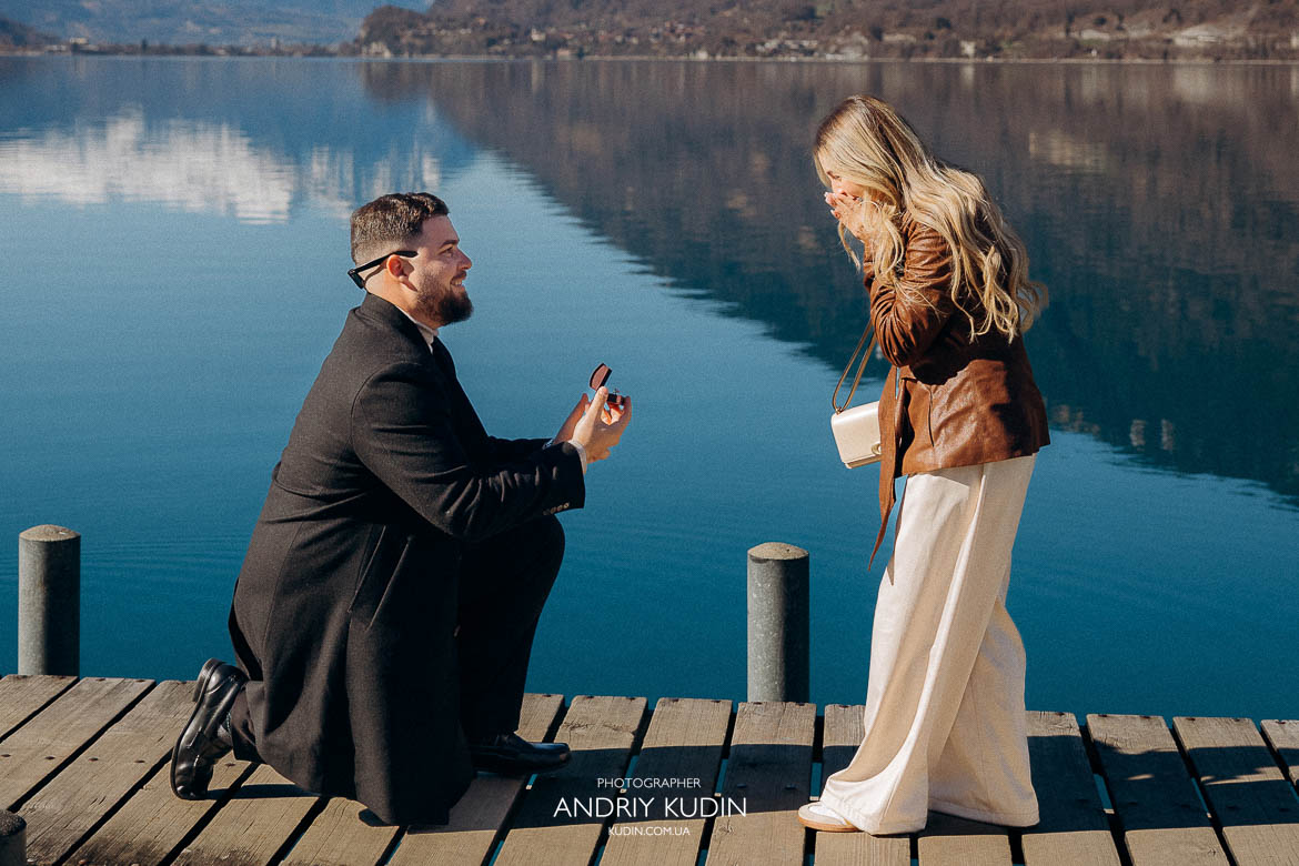Man on one knee proposing at Iseltwald pier Switzerland, turquoise Brienz Lake behind, 사랑의 불시착 촬영지 프로포즈 순간