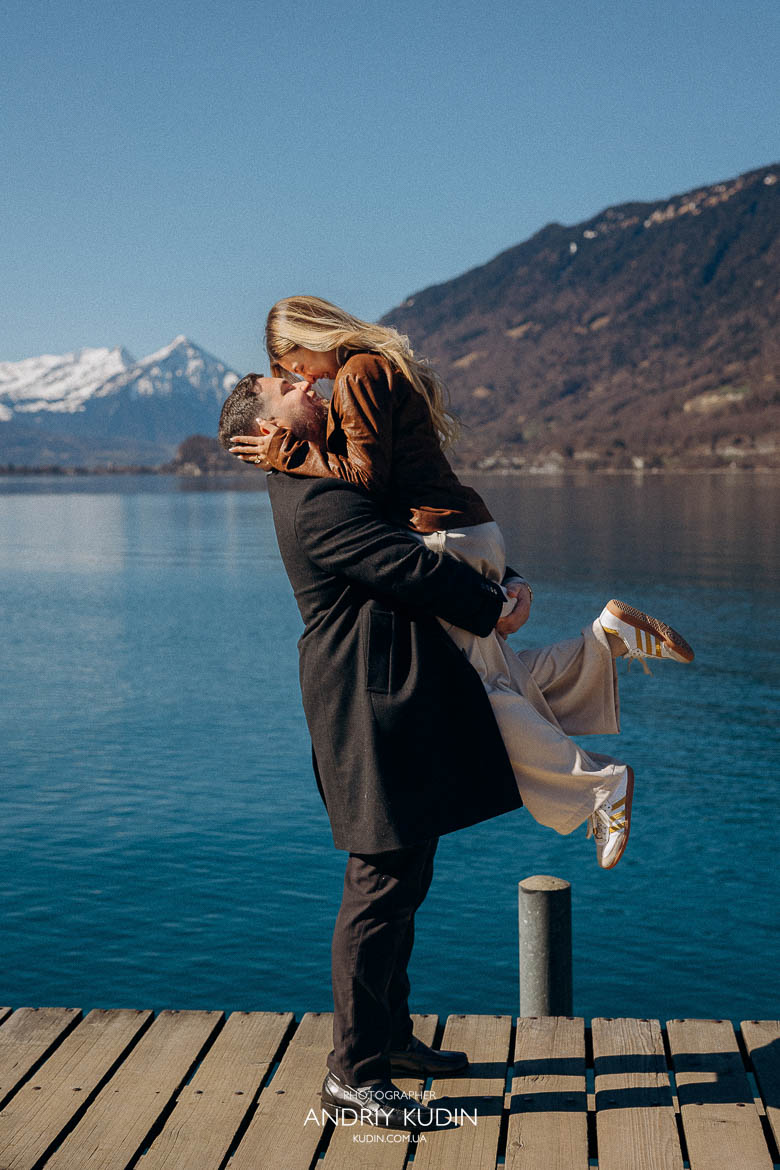 Emotional engagement moment on Lake Brienz pier, man giving ring, 스위스 프로포즈 반지 선물