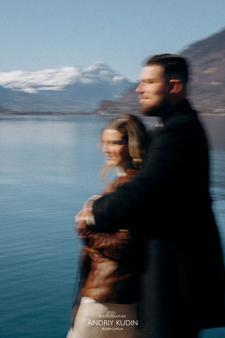 Couple standing at edge of pier looking at mountains after proposal, 스위스 브리엔츠 호수 프로포즈 풍경