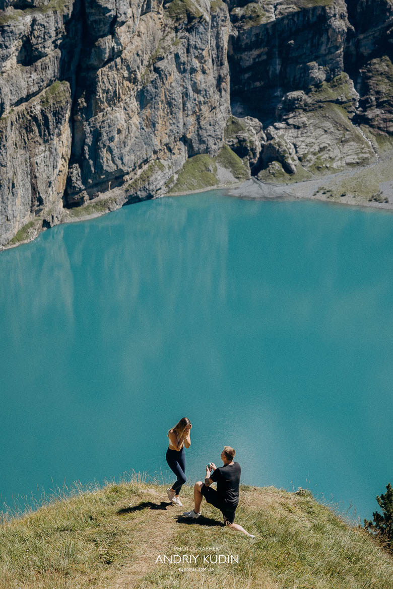 Man proposing on one knee at Lake Oeschinensee Switzerland