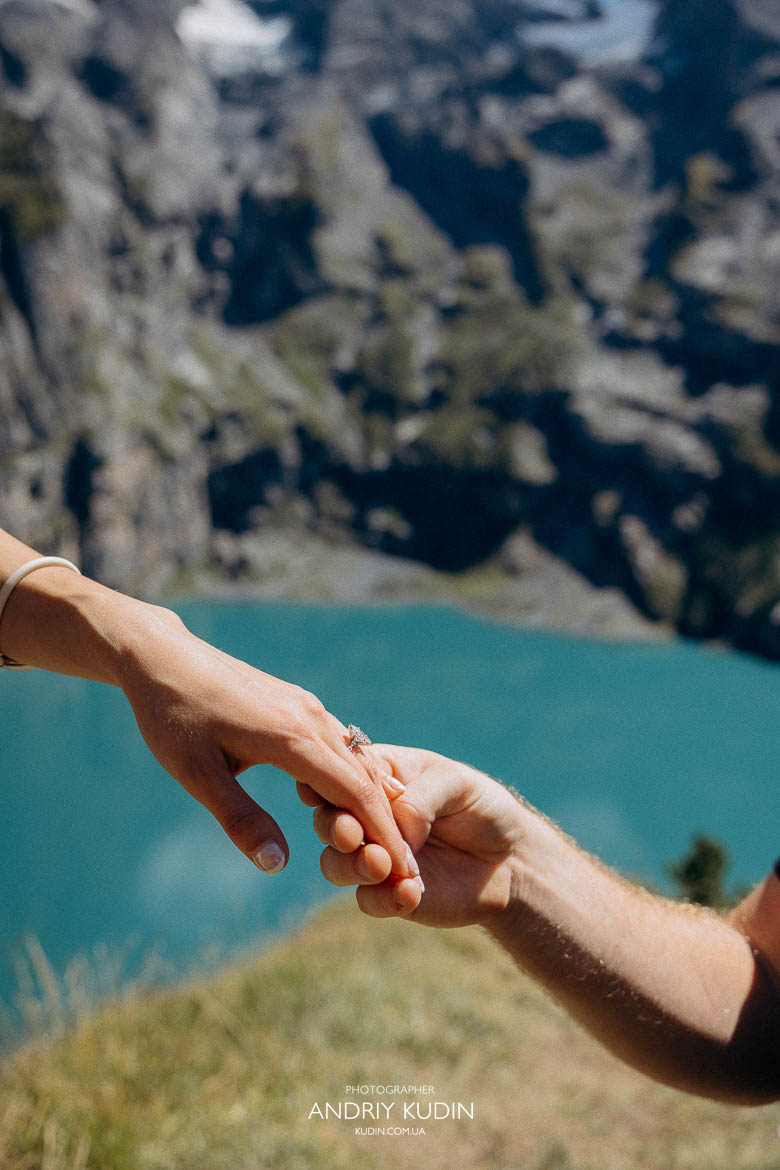 Man proposing on one knee at Lake Oeschinensee Switzerland