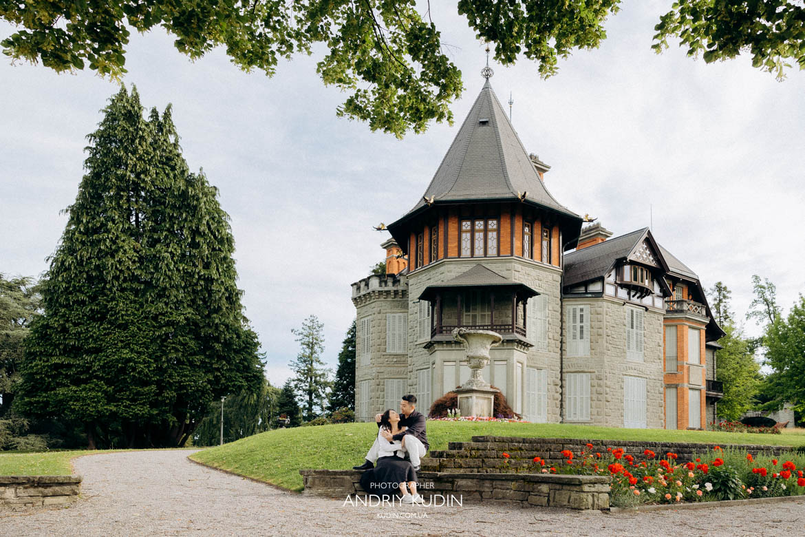 Wide shot of a couple alone in a hilltop park during a romantic Swiss engagement.