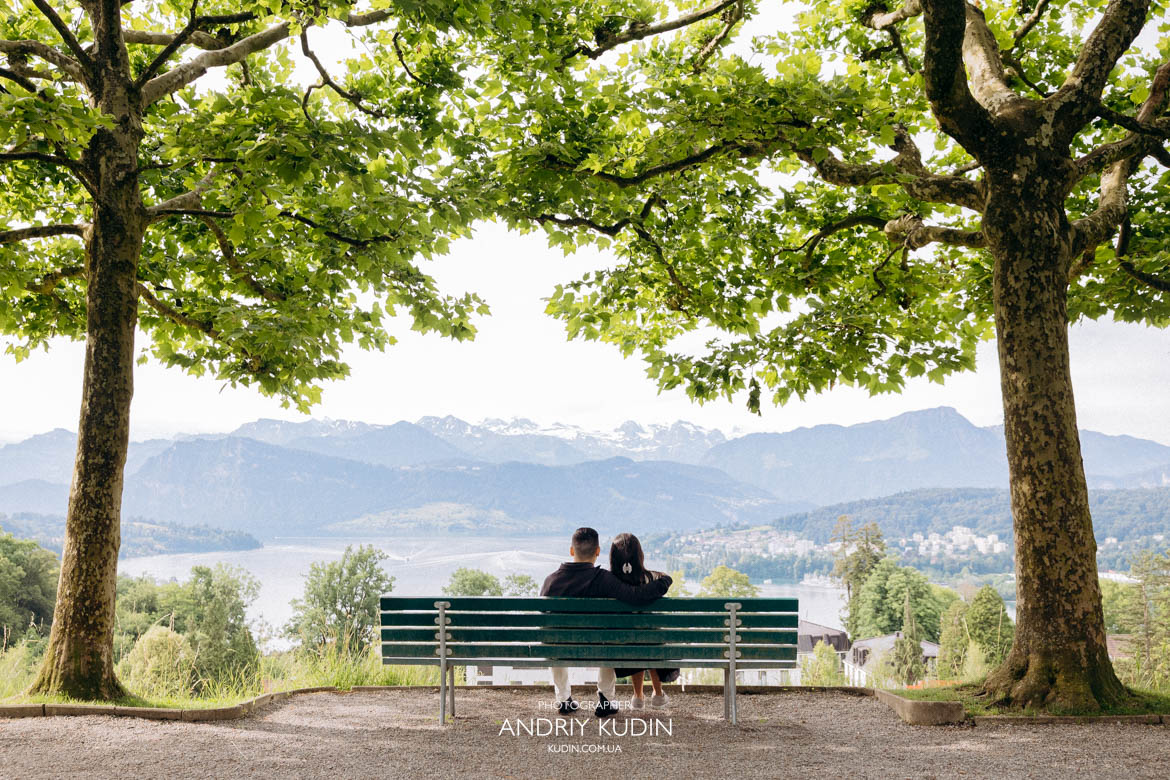 Groom-to-be holding a red ring box while kneeling on a scenic terrace in Lucerne. Groom-to-be holding a red ring box while kneeling on a scenic terrace in Lucerne.