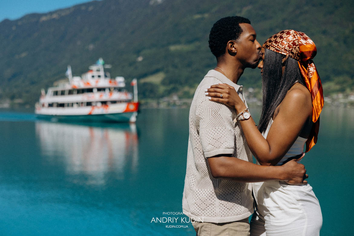 Romantic proposal Switzerland landscape with a happy couple kissing by the water. Iseltwald romantic proposal captured secretly by a local professional photographer.