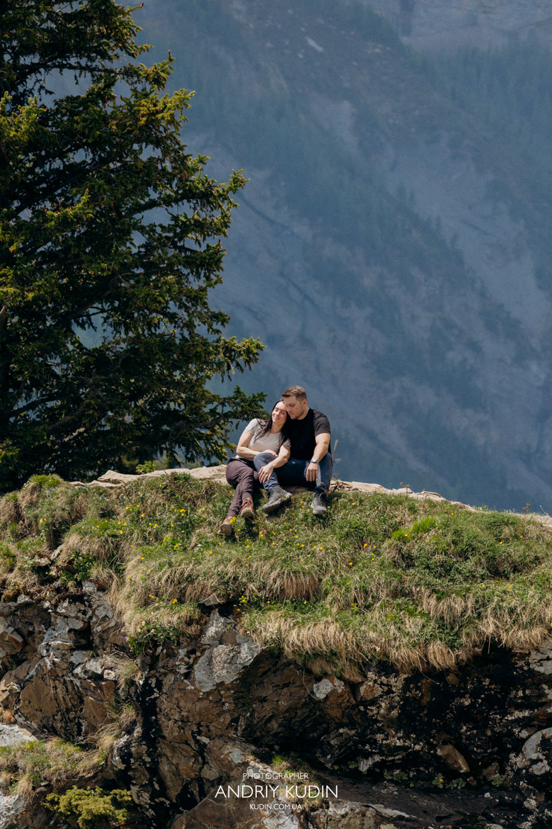 Romantic proposal Switzerland photography featuring a couple looking at the alpine scenery together.