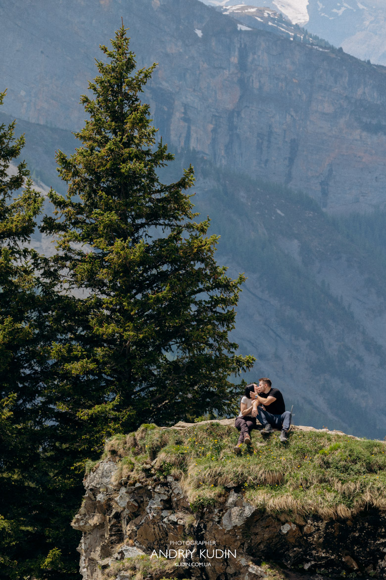 Romantic kiss at the most beautiful secret spot of Oeschinen Lake with clear blue water.