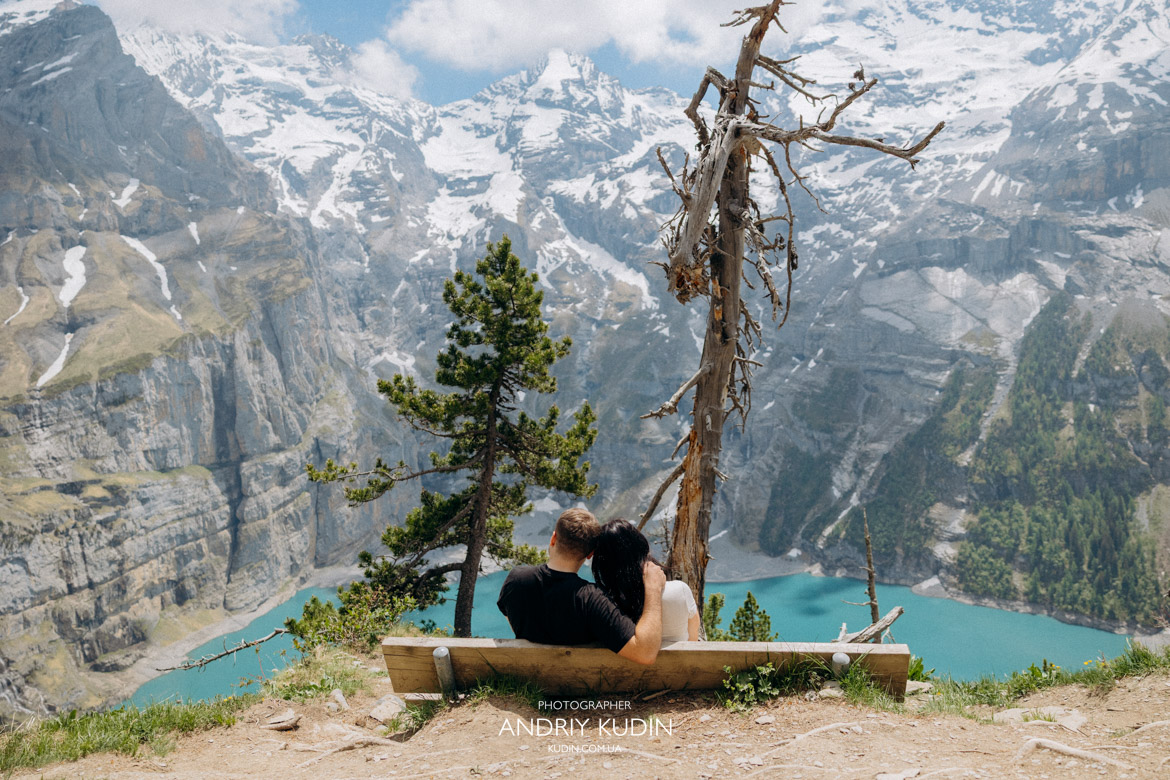 Alpine lake proposal Switzerland showcasing crystal clear blue water and mountains.