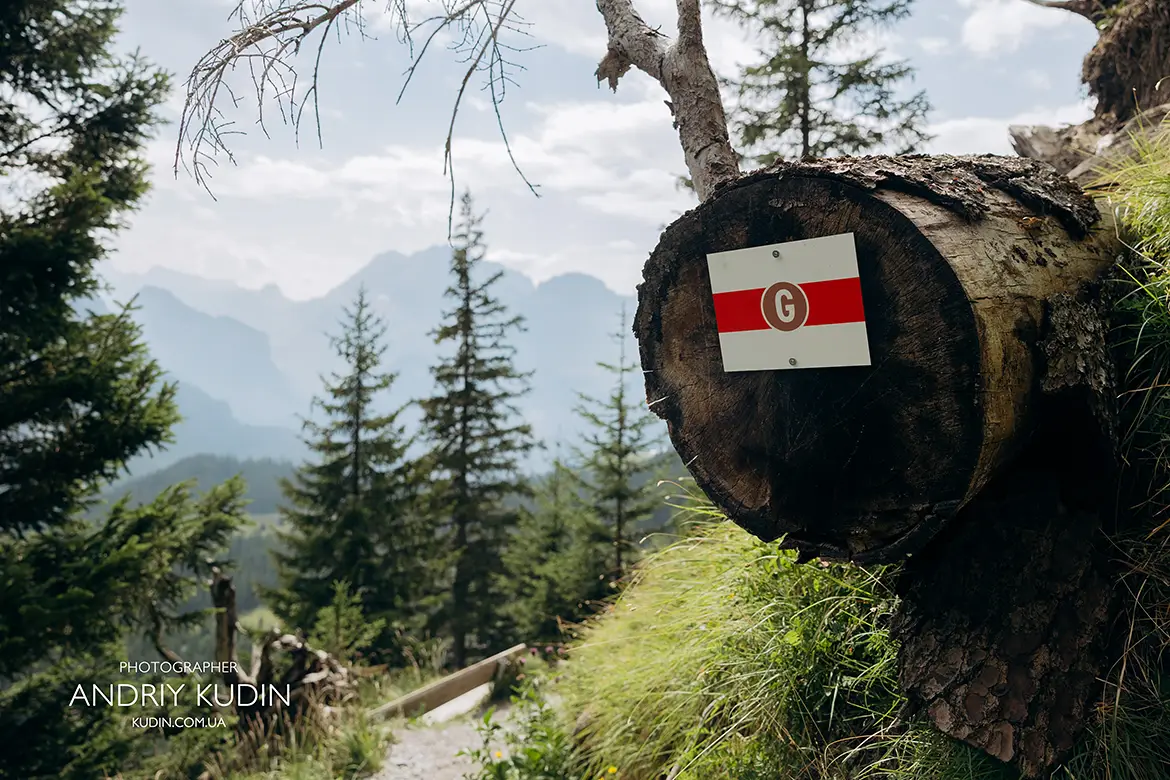 Hiking trail marker on Oeschinensee panoramic route with Swiss Alps background
