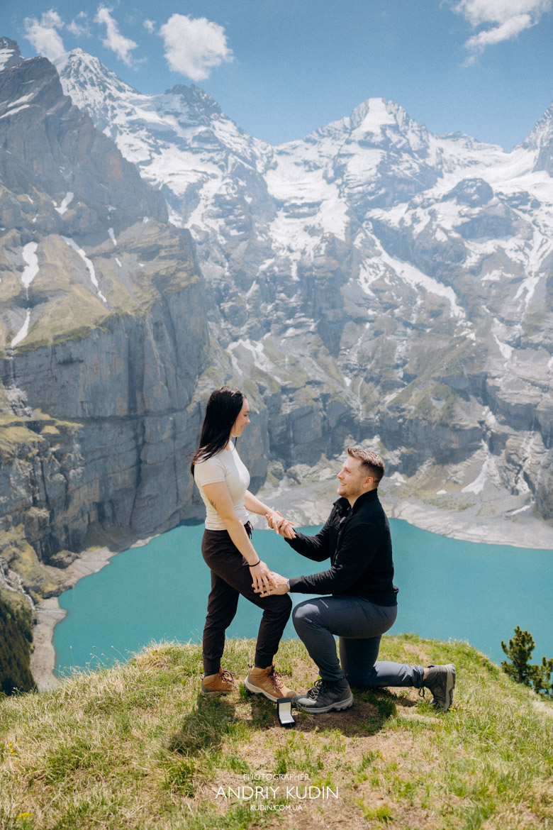 Surprise proposal Swiss Alps backdrop with a couple hugging after saying yes.