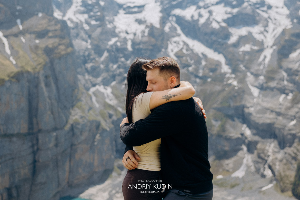 Emotional couple during an Oeschinen Lake proposal in the Swiss Alps.